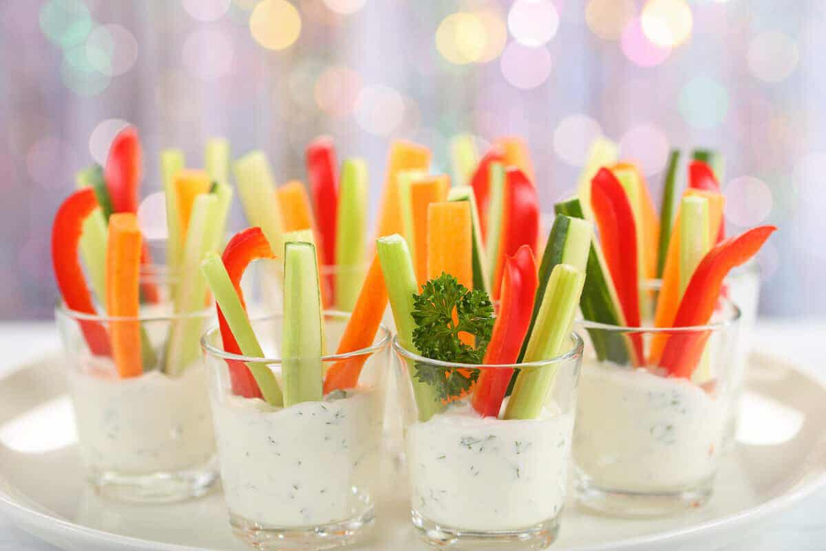 Cucumber, celery and red pepper sticks in a verrine cup filled with creamy dressing