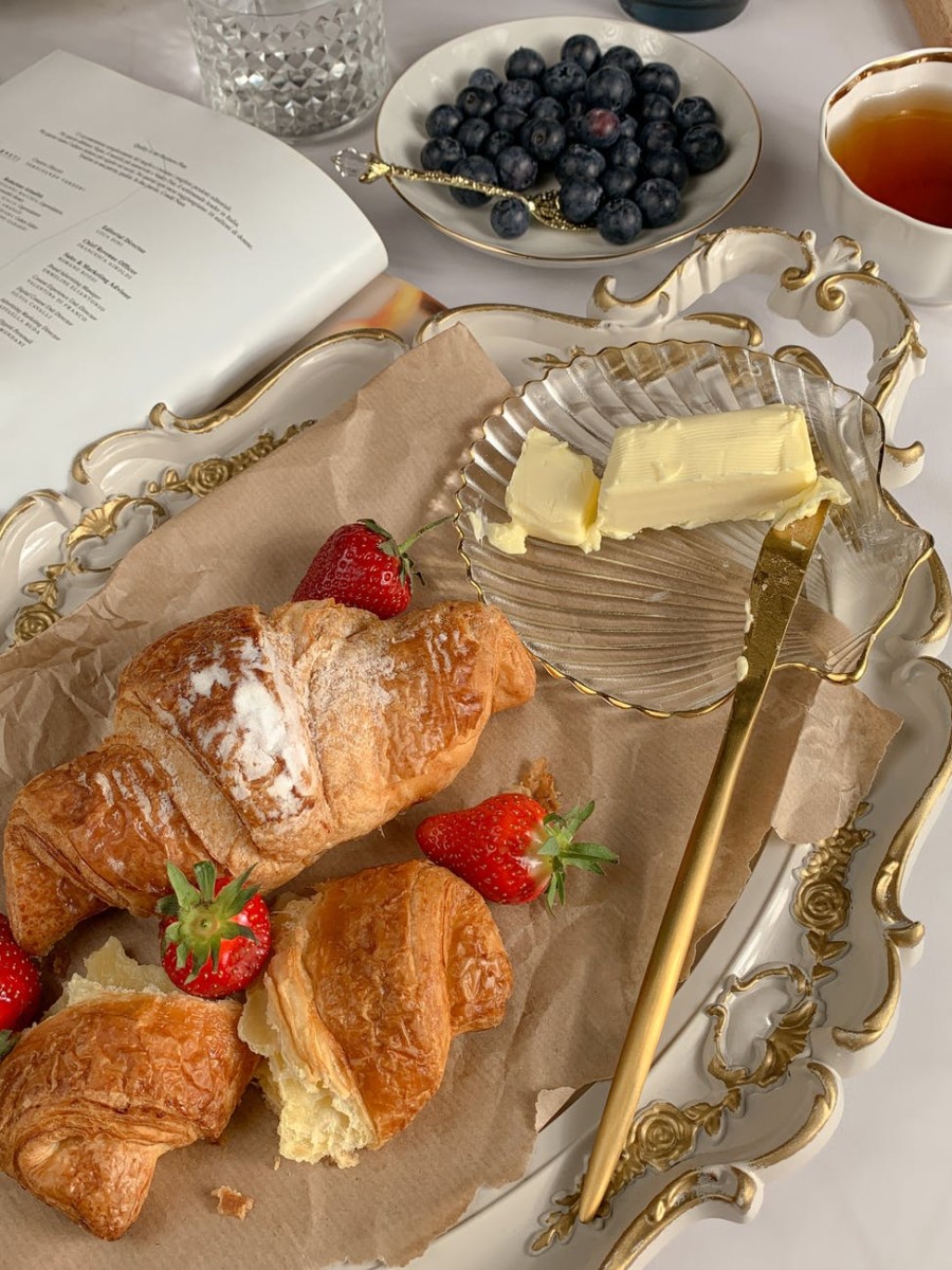 croissants with strawberries beside butter and blueberries